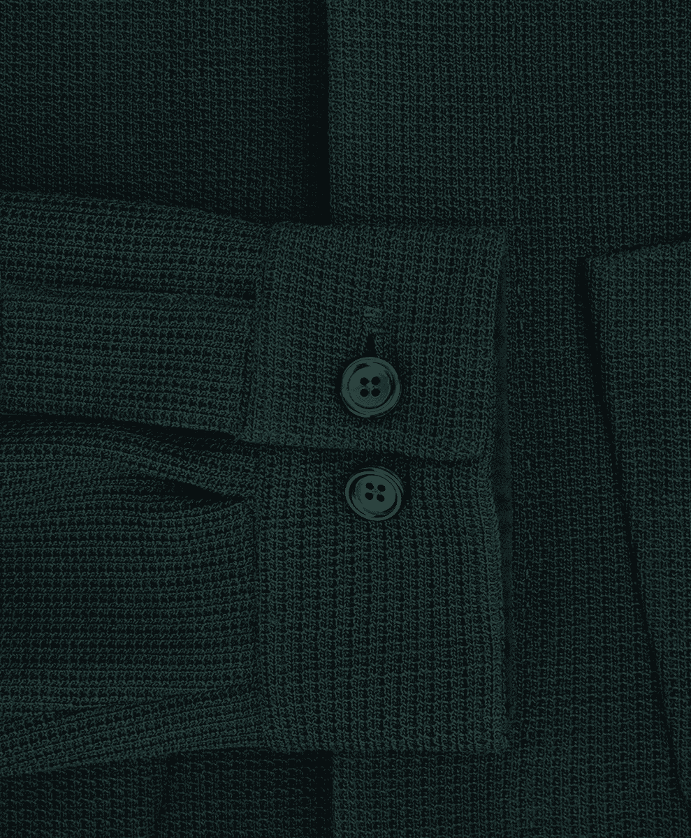 Macro shot of a dark teal knitted overshirt weave and cuff buttons.
