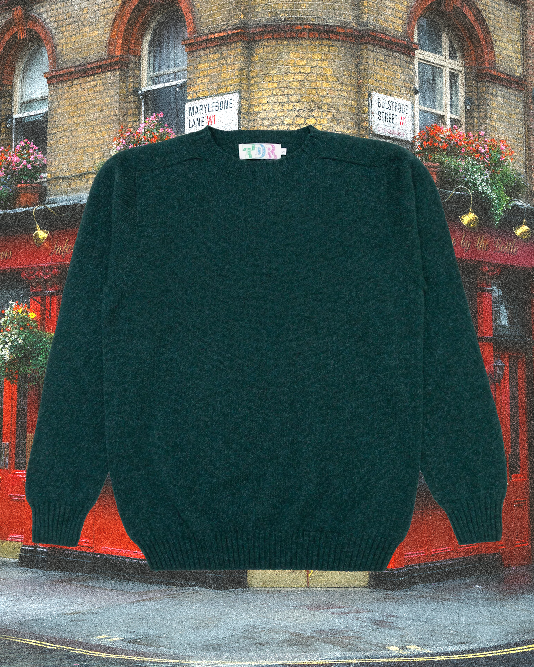A dark green knitted sweater with ribbed cuffs on a Marylebone street corner.