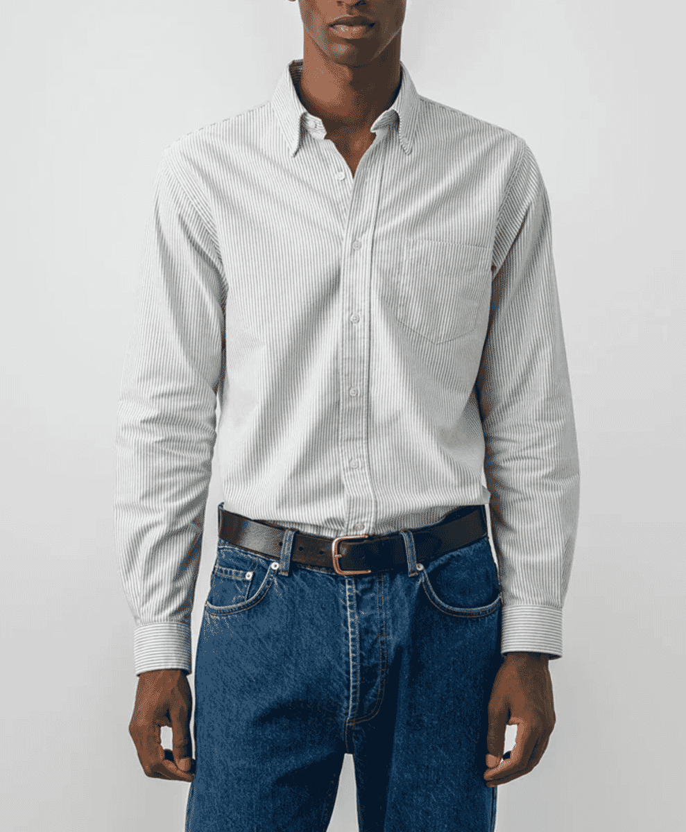 A man wearing a vertically striped Oxford shirt with blue denim.