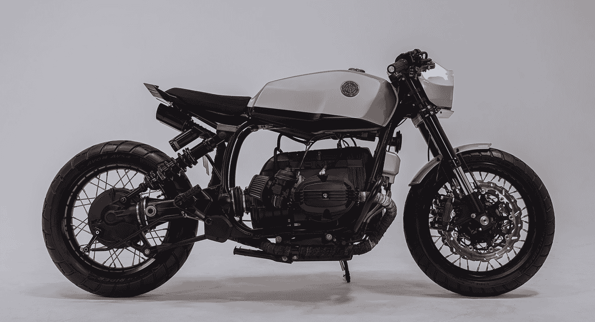 A minimalist custom motorcycle with a sleek frame and single seat against a stark white background.