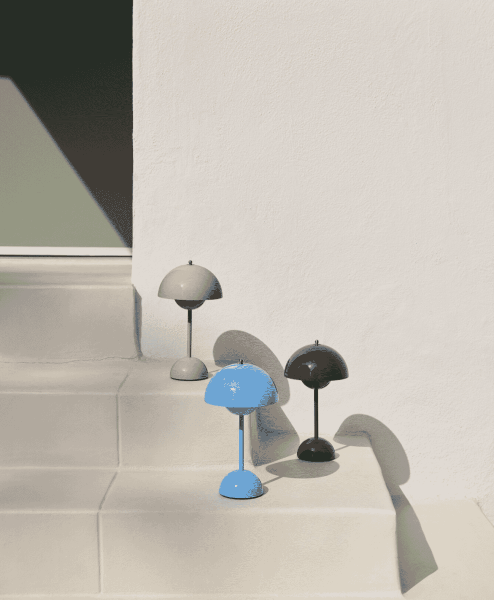 Three mushroom-shaped portable lamps in different colors on stone steps.