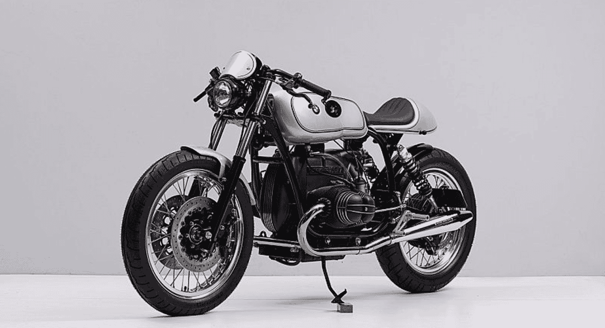 Black-and-white studio shot of the front profile of the R100 motorcycle featuring a round headlight.