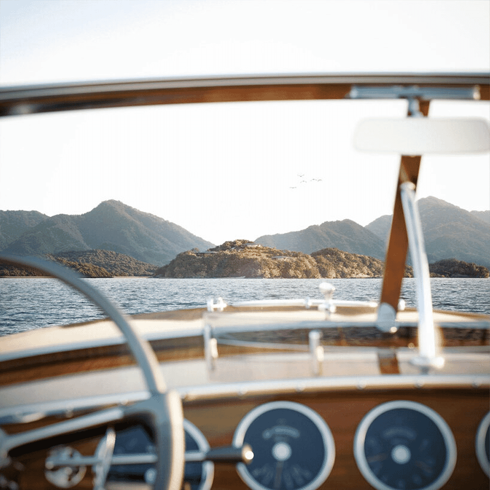 View from the cockpit of a classic wooden boat approaching the mountainous islands of the Seto Inland Sea.