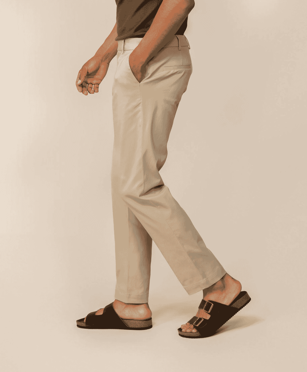 Side profile of a man wearing a dark brown t-shirt and beige chinos.