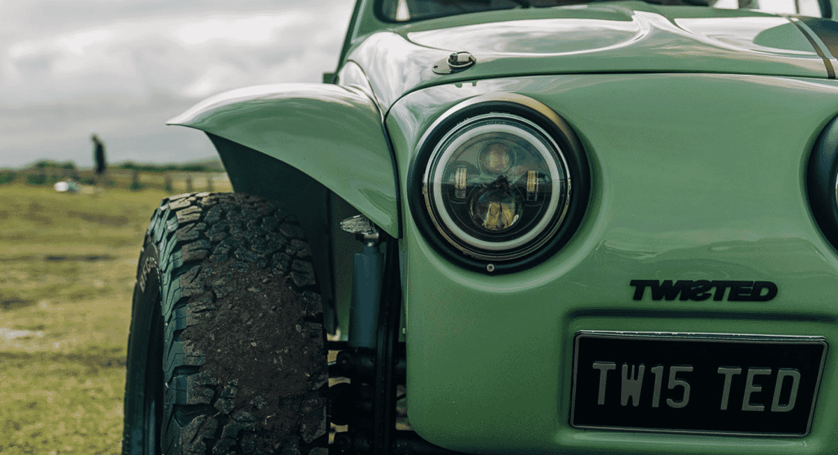 Close-up of a green off-road vehicle featuring 'TWISTED' branding and rugged tires.