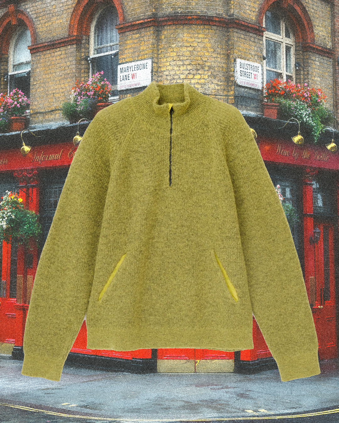 An olive-green quarter-zip sweater with yellow zipper accents displayed against a London street scene.