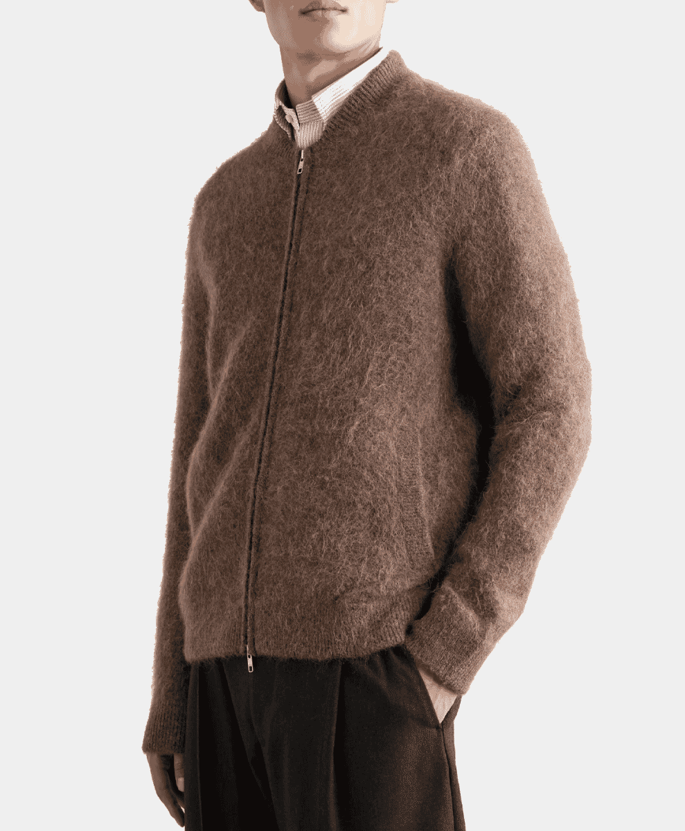 A model in a fuzzy brown alpaca zip-up over a striped shirt.
