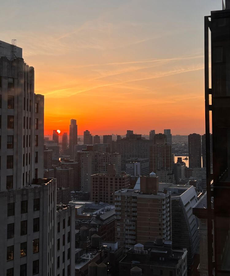 A woman watching the first sunrise of the year over a calm horizon