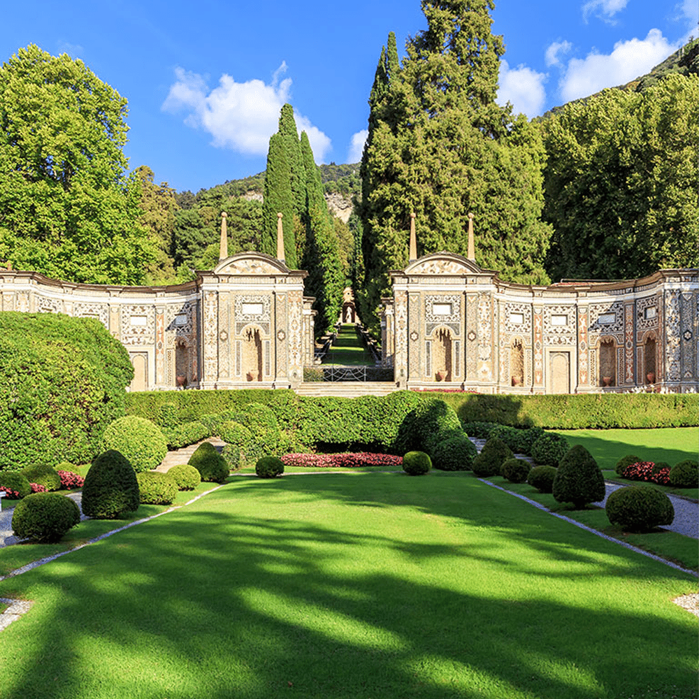 An Italian Renaissance garden with stone walls, cypress trees, and manicured hedges.
