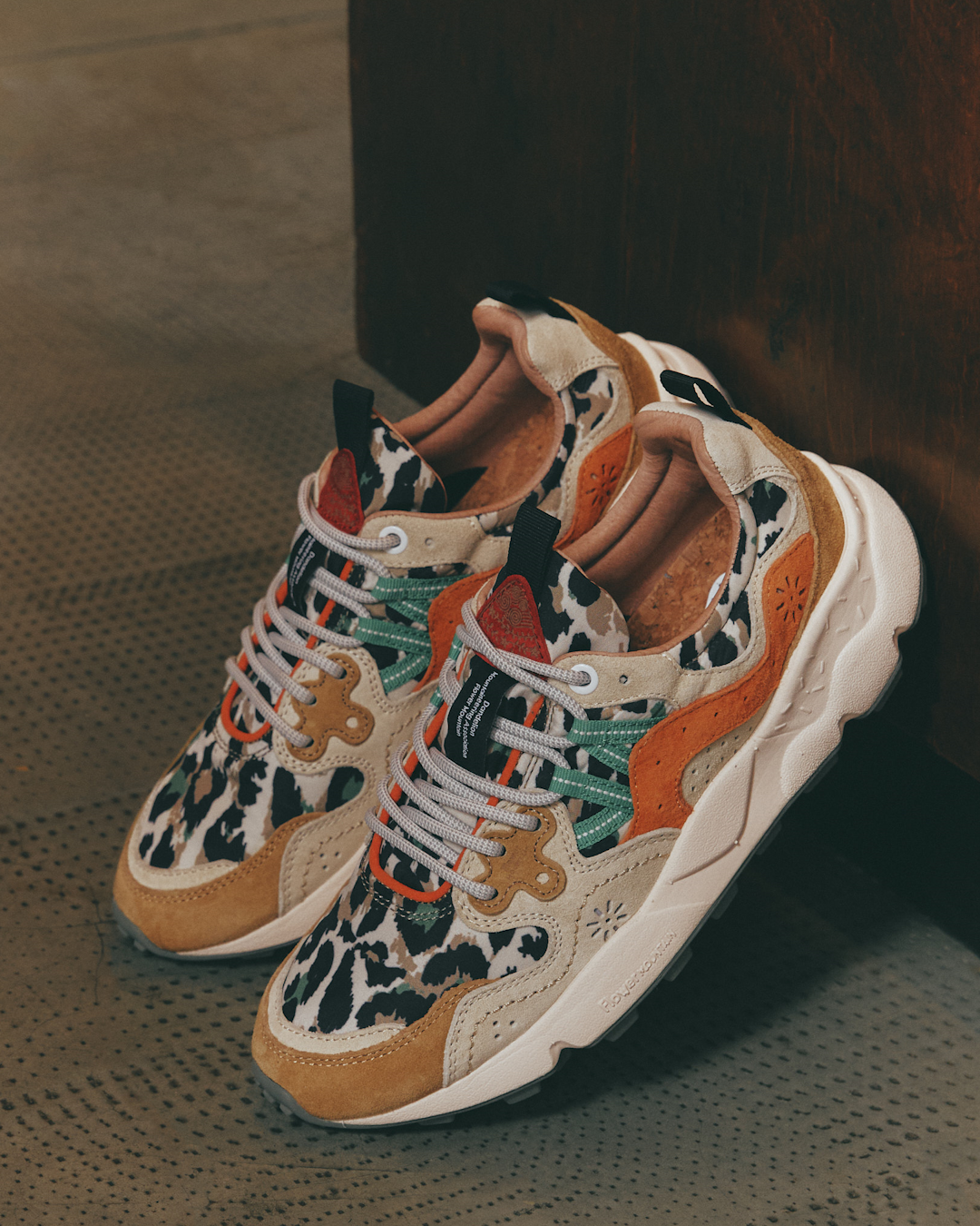 A brown suede sneaker model styled with neutral wide-leg trousers.