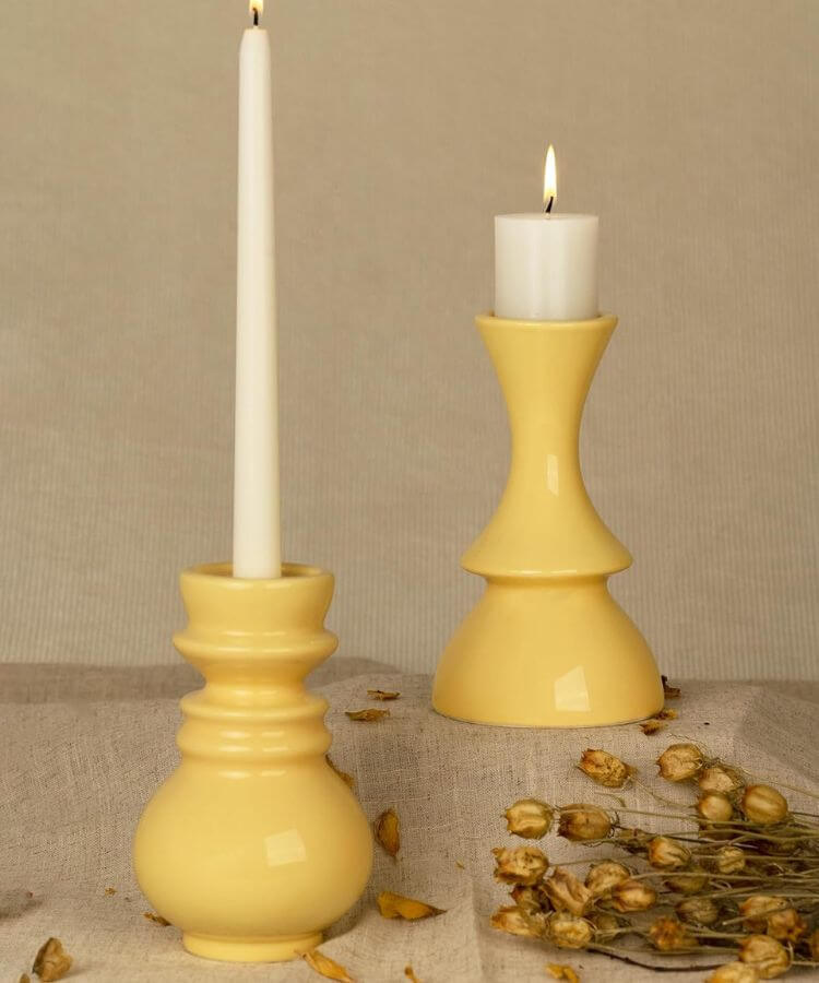 Set of vibrant yellow ceramic candle holders.