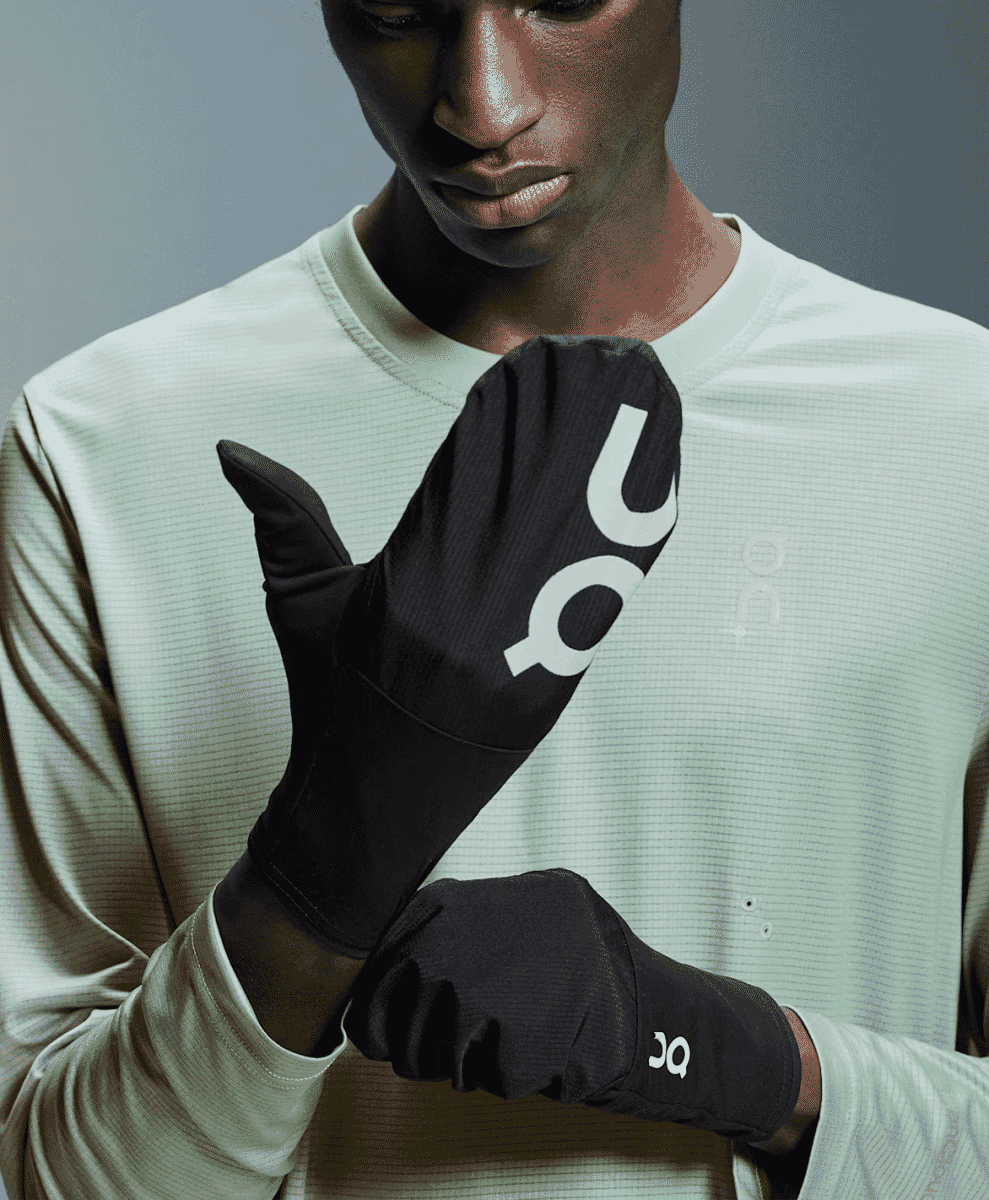 Detail shot of black fingerless athletic gloves with white branding.