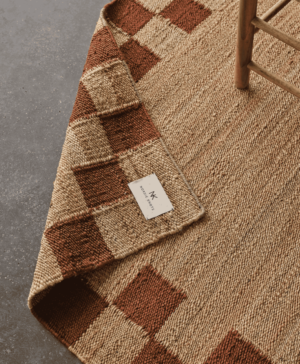 Close-up of a textured woven checkered rug in brown and beige tones.