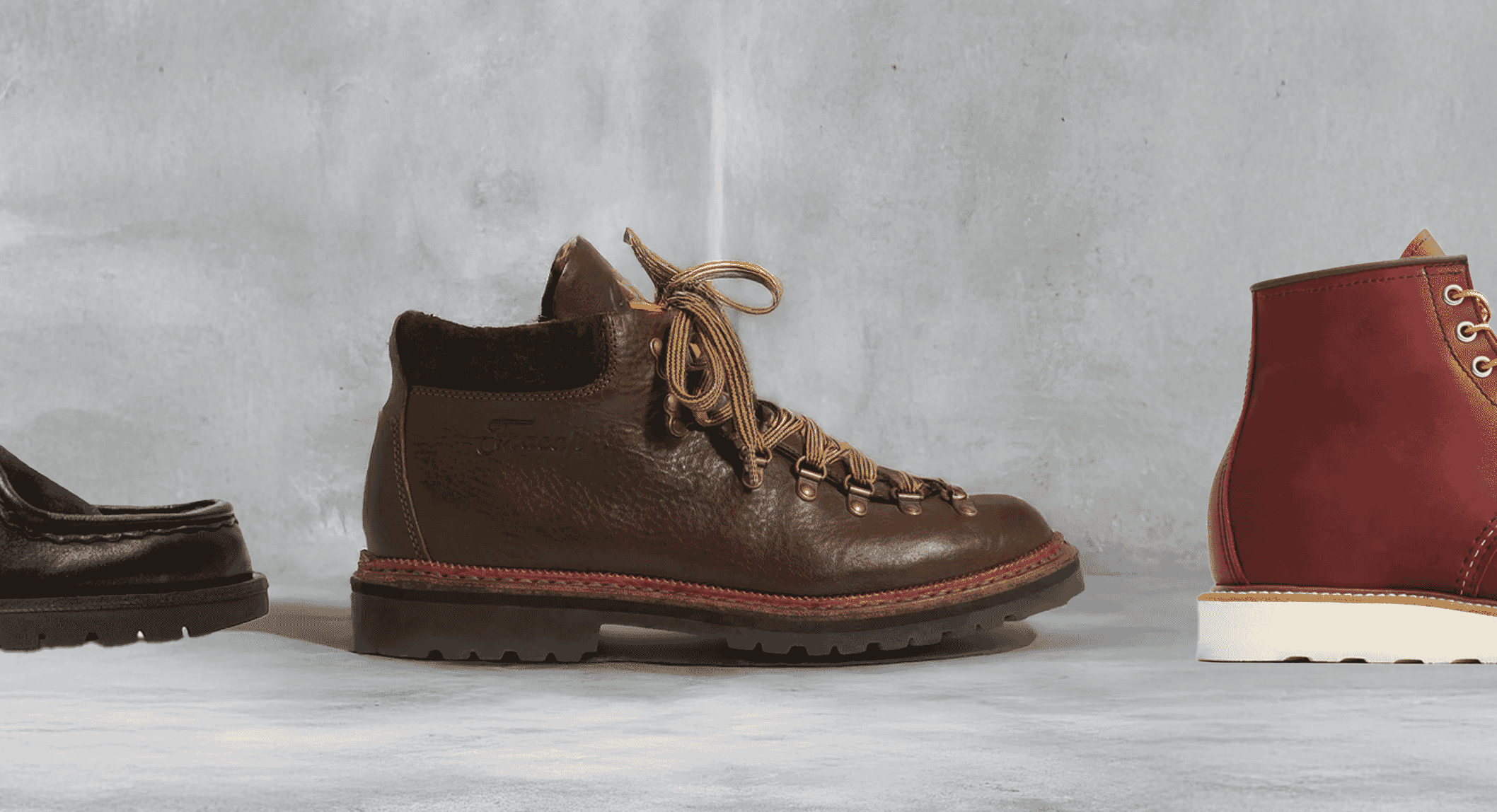 A red suede chukka boot displayed alongside other footwear styles.