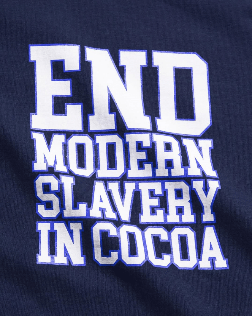 Navy blue t-shirt with white text reading END MODERN SLAVERY IN COCOA.