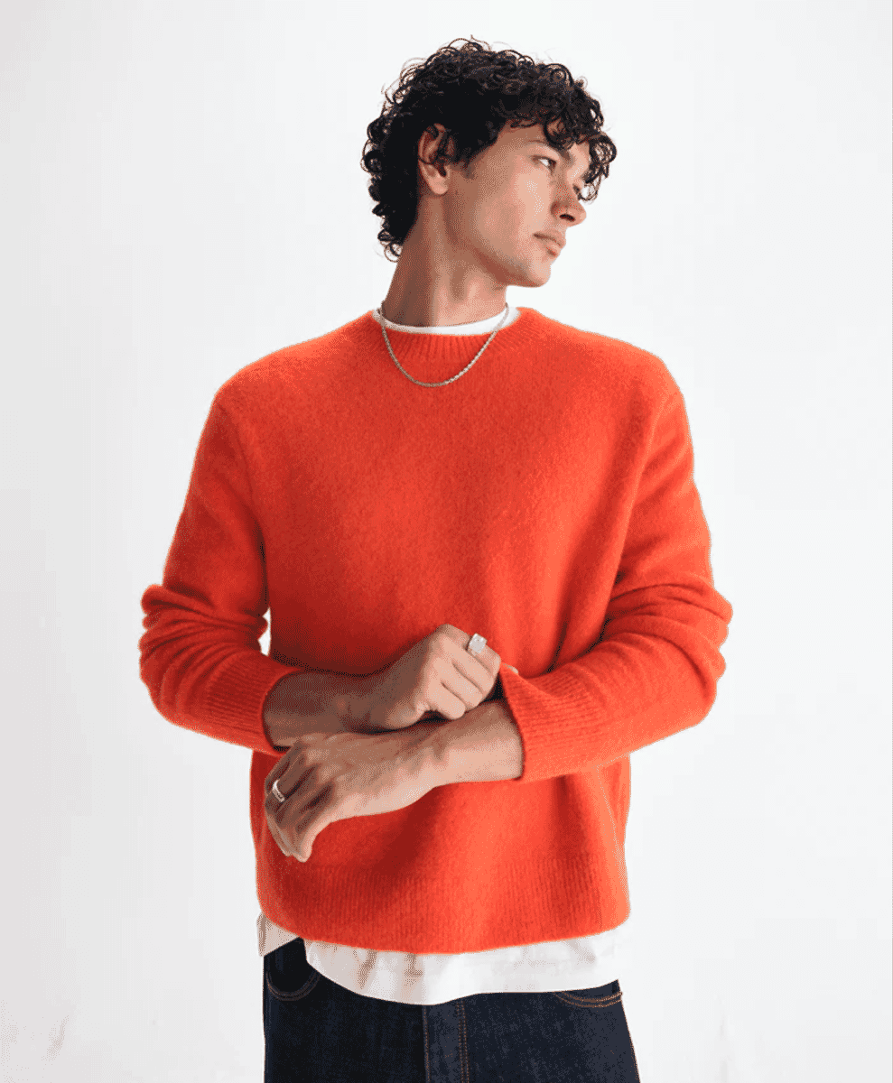 A man in a vibrant orange fluffy wool crewneck sweater over a white t-shirt.