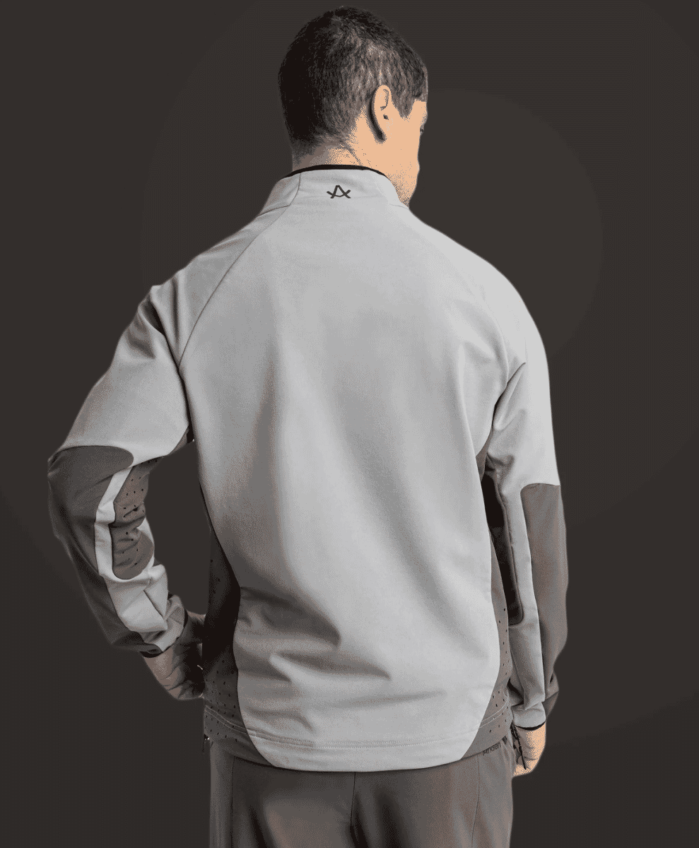 Back view of a man wearing a gray and dark gray athletic zip-up jacket.