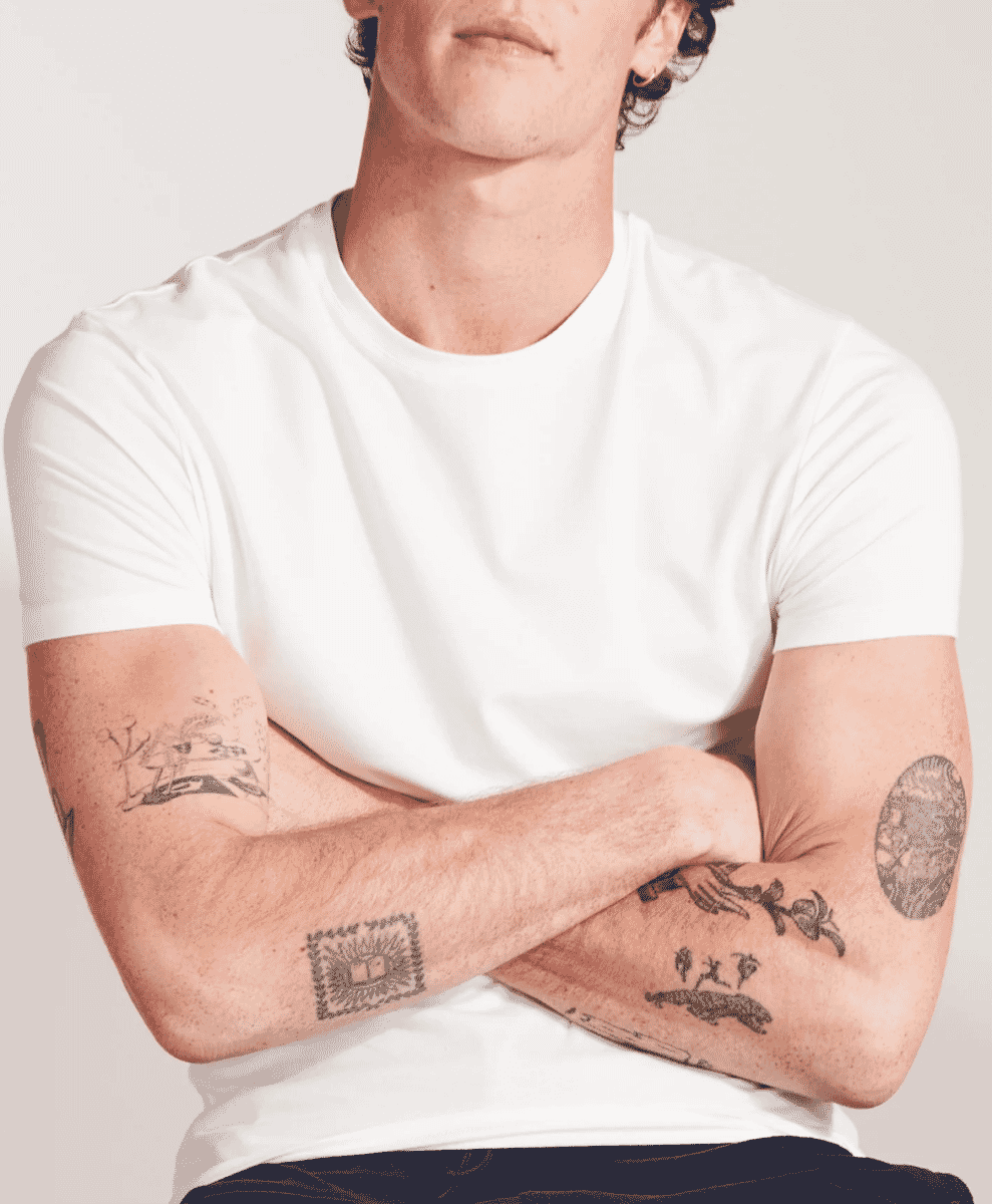 Model standing in a minimalist white crew-neck t-shirt.