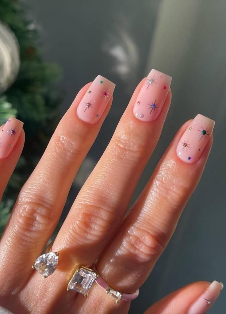 Intricate holiday nail art with delicate metallic detailing and stones.