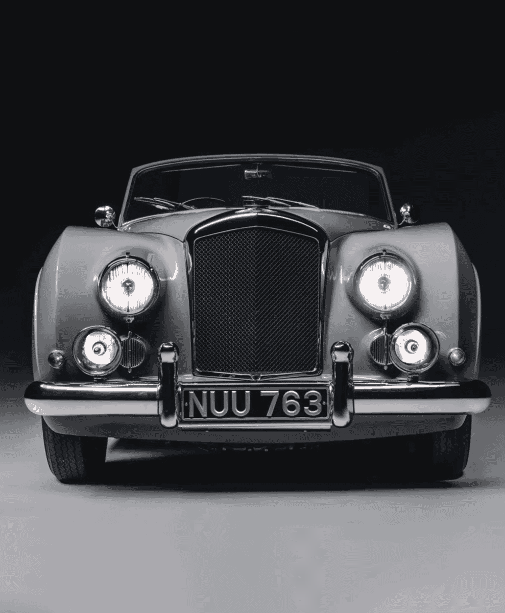 Monochrome portrait of a 1953 Bentley front grille and headlights.