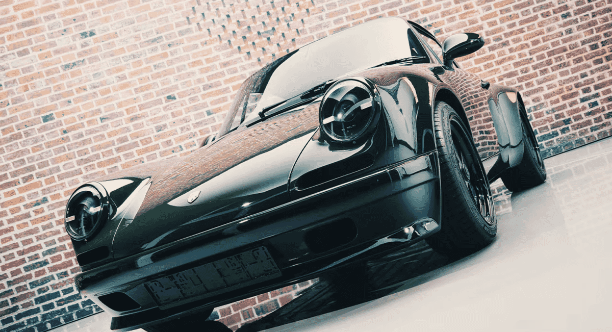 High-gloss black Porsche sports car parked in front of a brick wall texture.