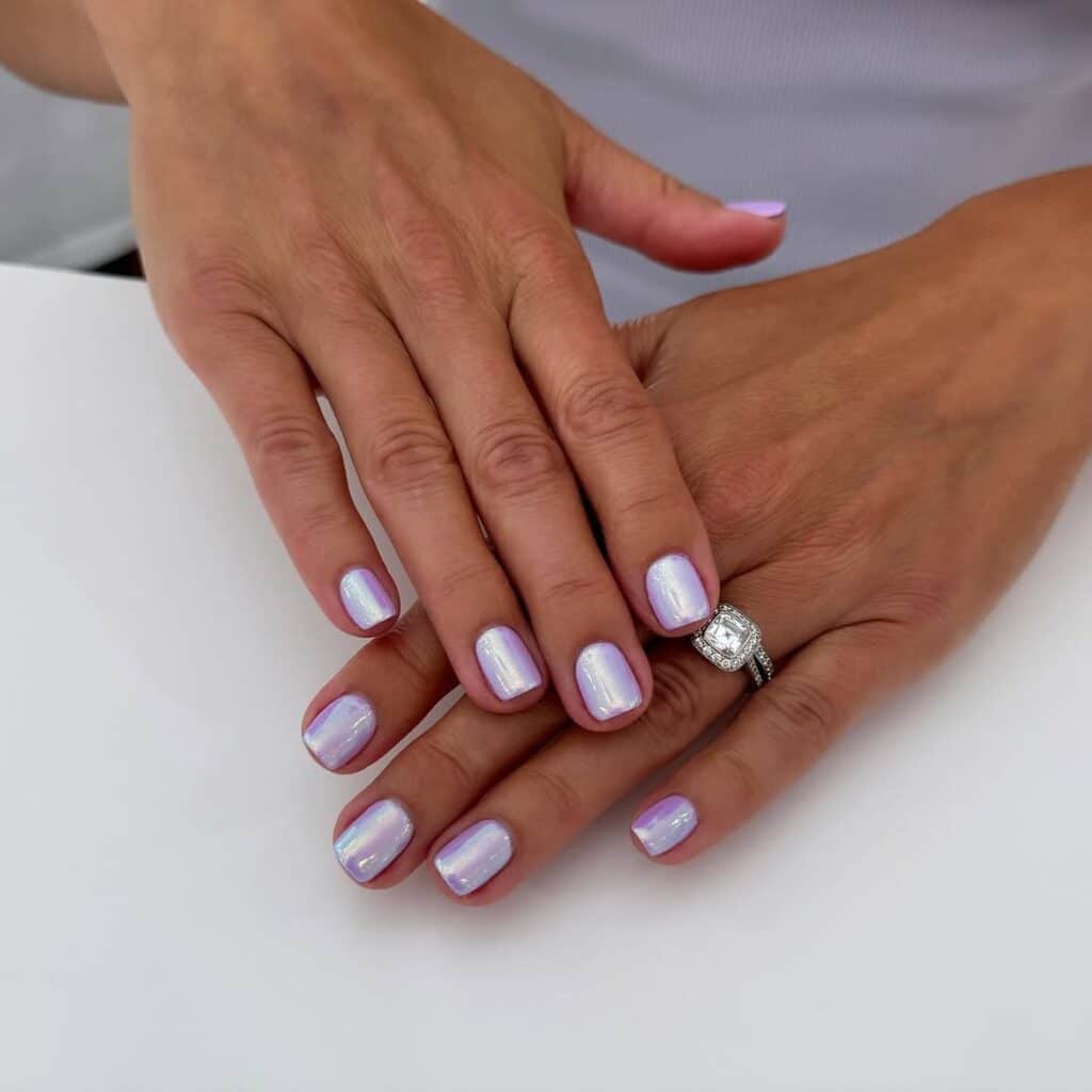 Elegant pearlized almond nails with an iridescent sheen by @oakspanails_winnetka.
