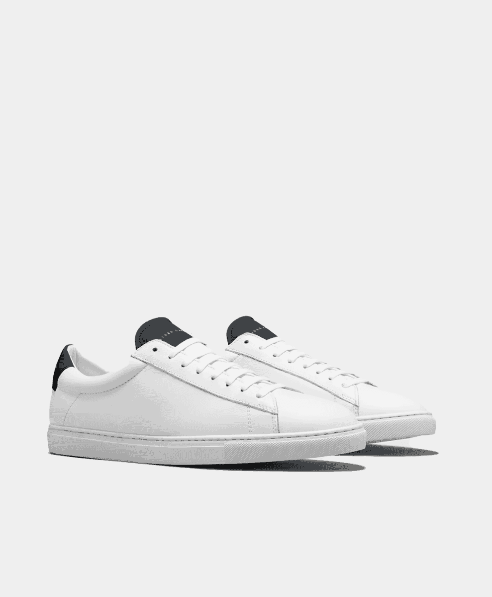 Minimalist white leather low-top sneakers with black heel tabs.