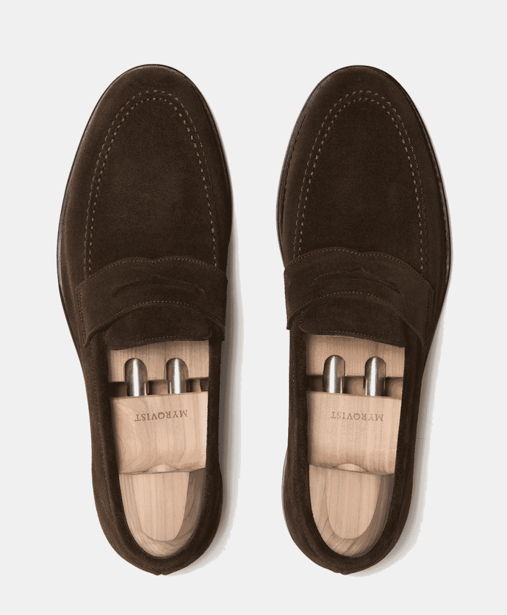 Top-down view of dark brown suede loafers with wooden shoe trees