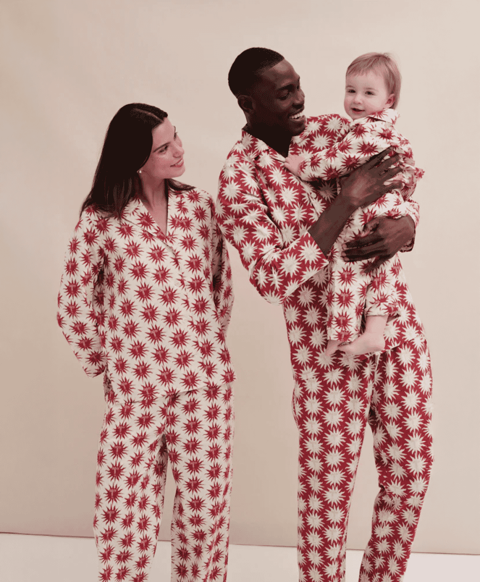 A family wearing matching red and white starburst-patterned pajamas.