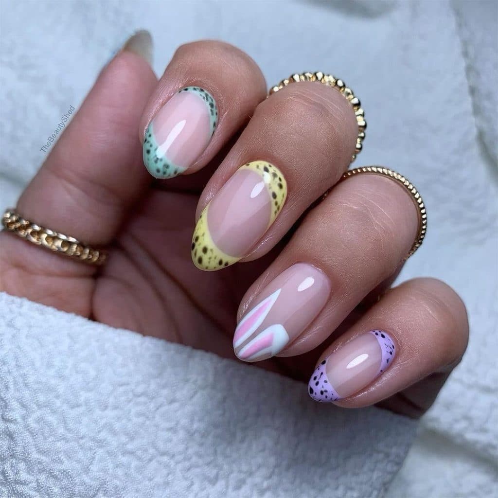 Nail art with leopard prints, bunny ears, and French tips with gold rings.