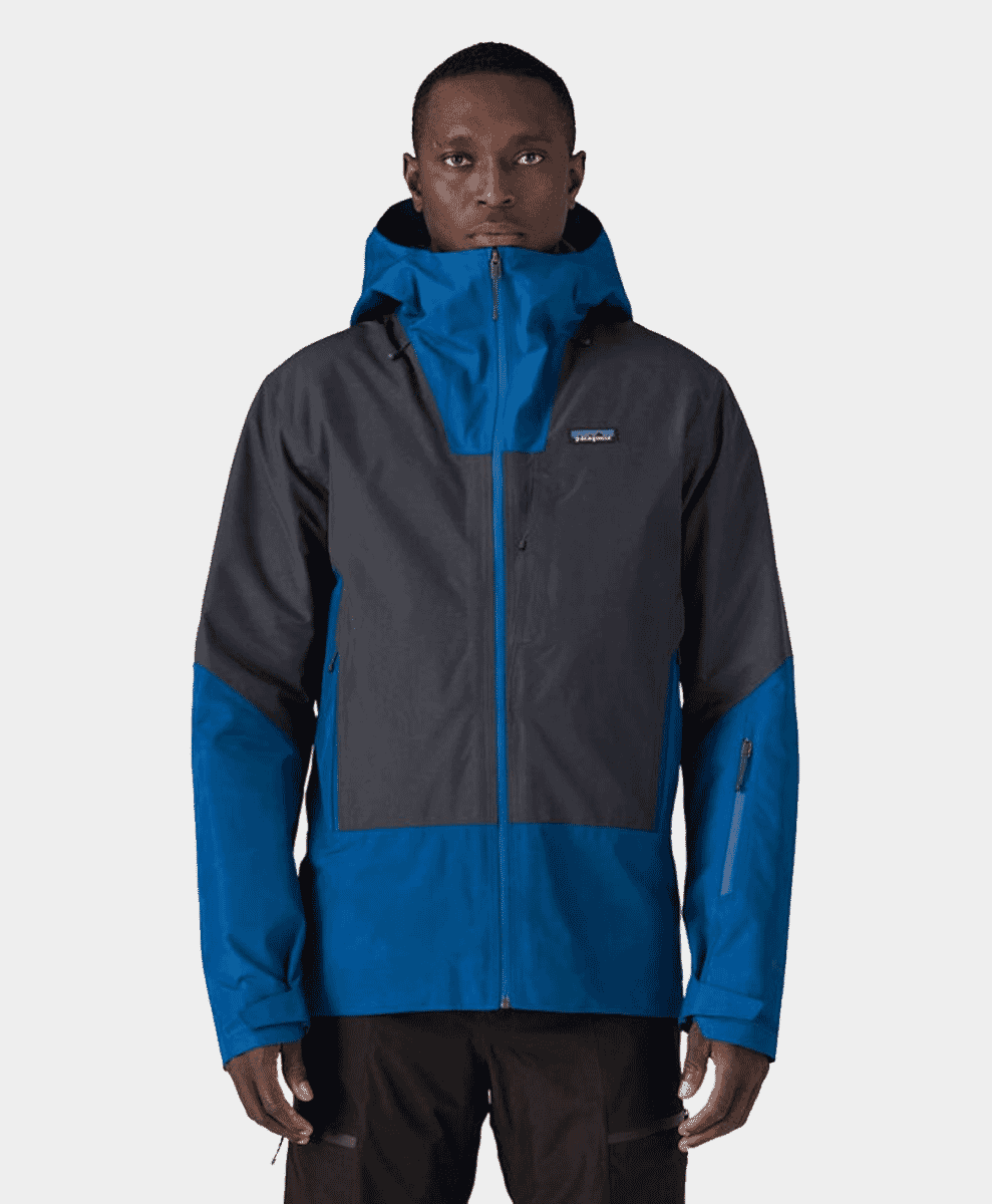 Model wearing a Patagonia color-blocked outdoor jacket with blue and dark gray panels.