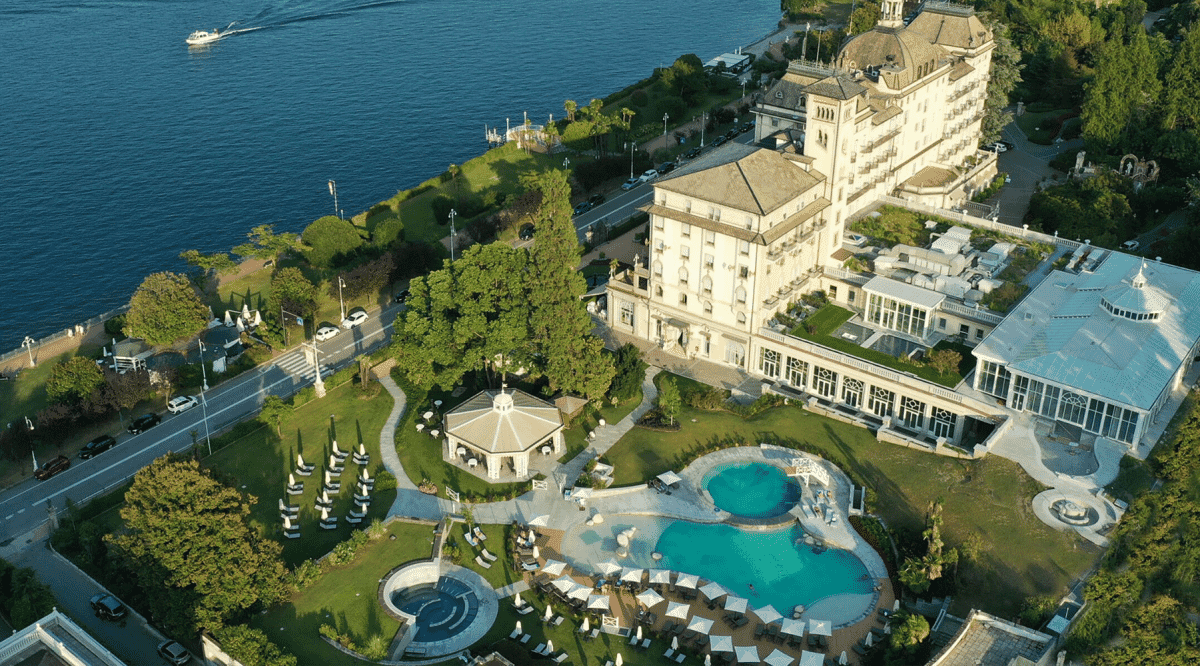 Aerial view of a neoclassical lakeside resort with formal gardens and classical architecture.