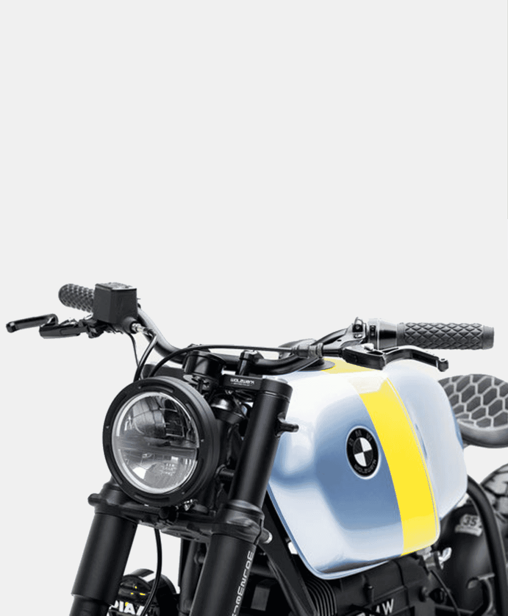 Front-quarter view of a custom BMW motorcycle showing the minimalist handlebars and round retro headlight.