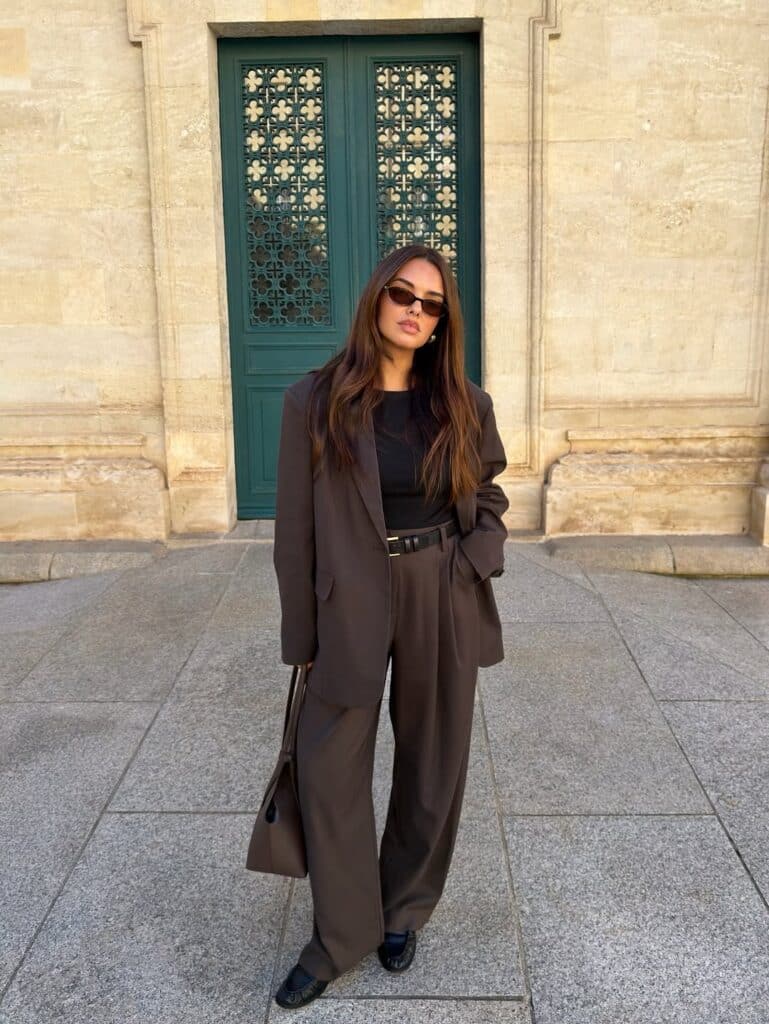 A clean, minimalist work outfit in neutral grey tones reflecting 90s professional style.