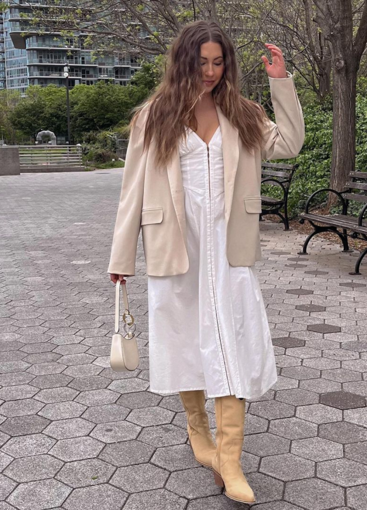 Lifestyle photo of influencer @trendingwithtinsley wearing cowboy boots with an airy dress.