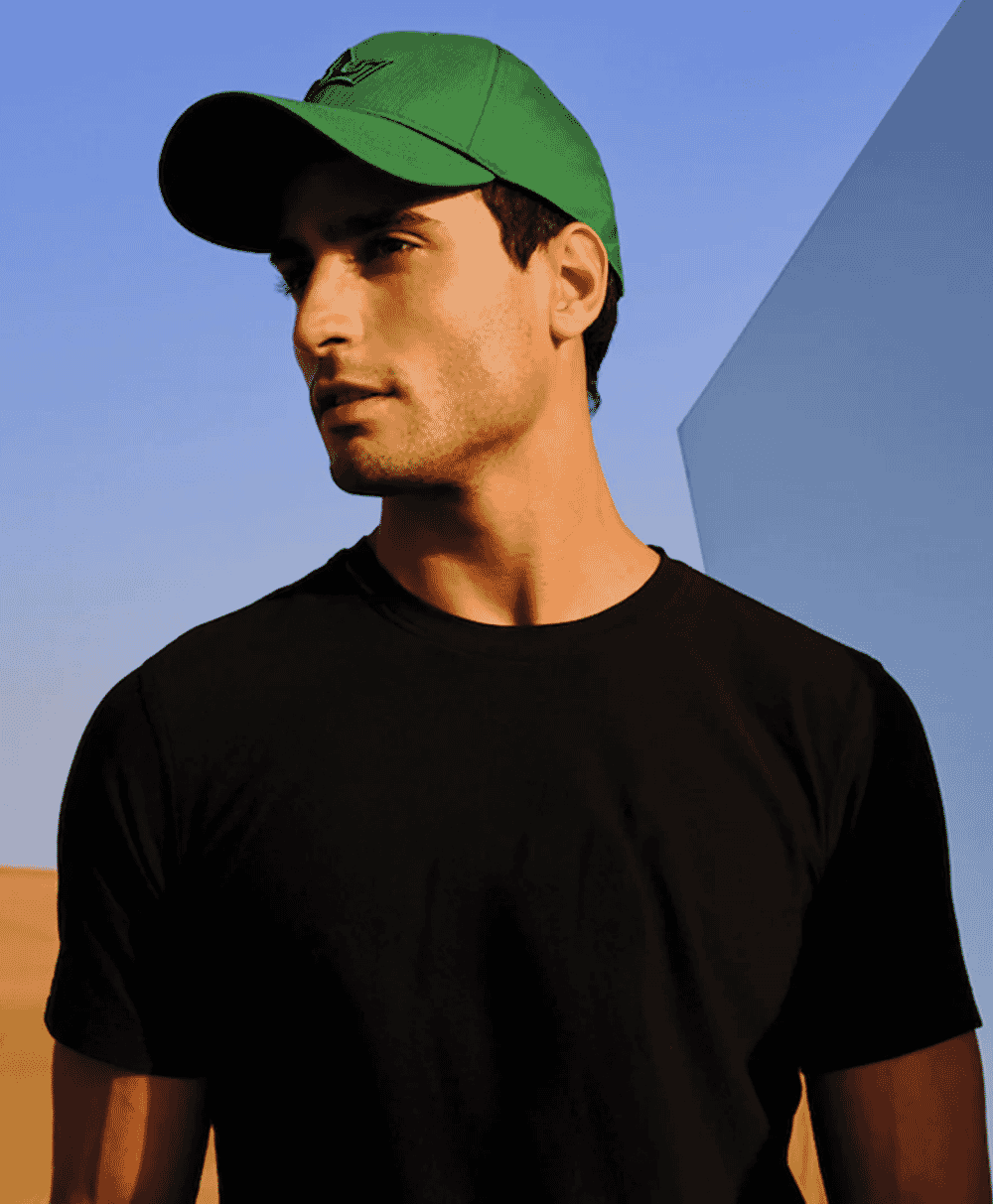 Man wearing a dark green cap in profile against a geometric background.