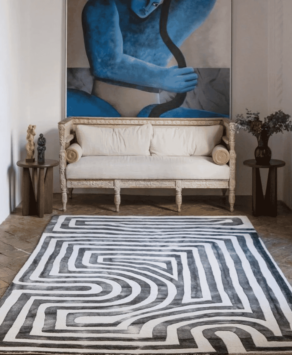 Stylish living room with an ornate white sofa and a high-contrast black-and-white geometric rug.