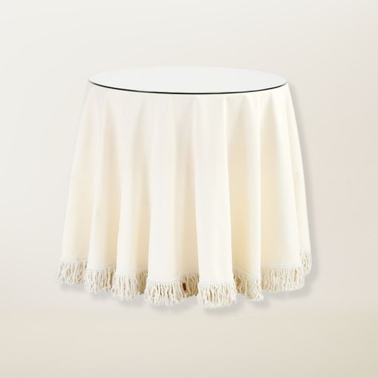 A small round side table with a white fabric skirt.