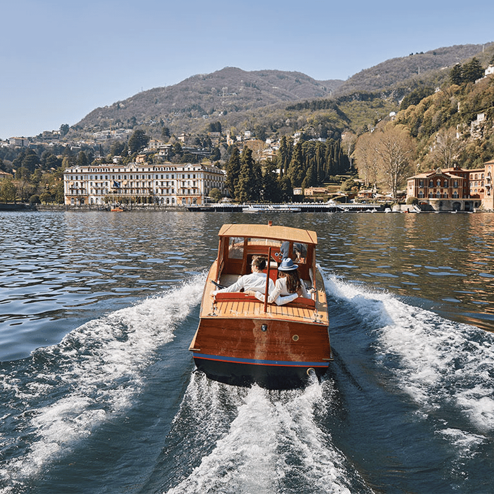 A couple relaxing on a classic wooden motorboat on Lake Como.