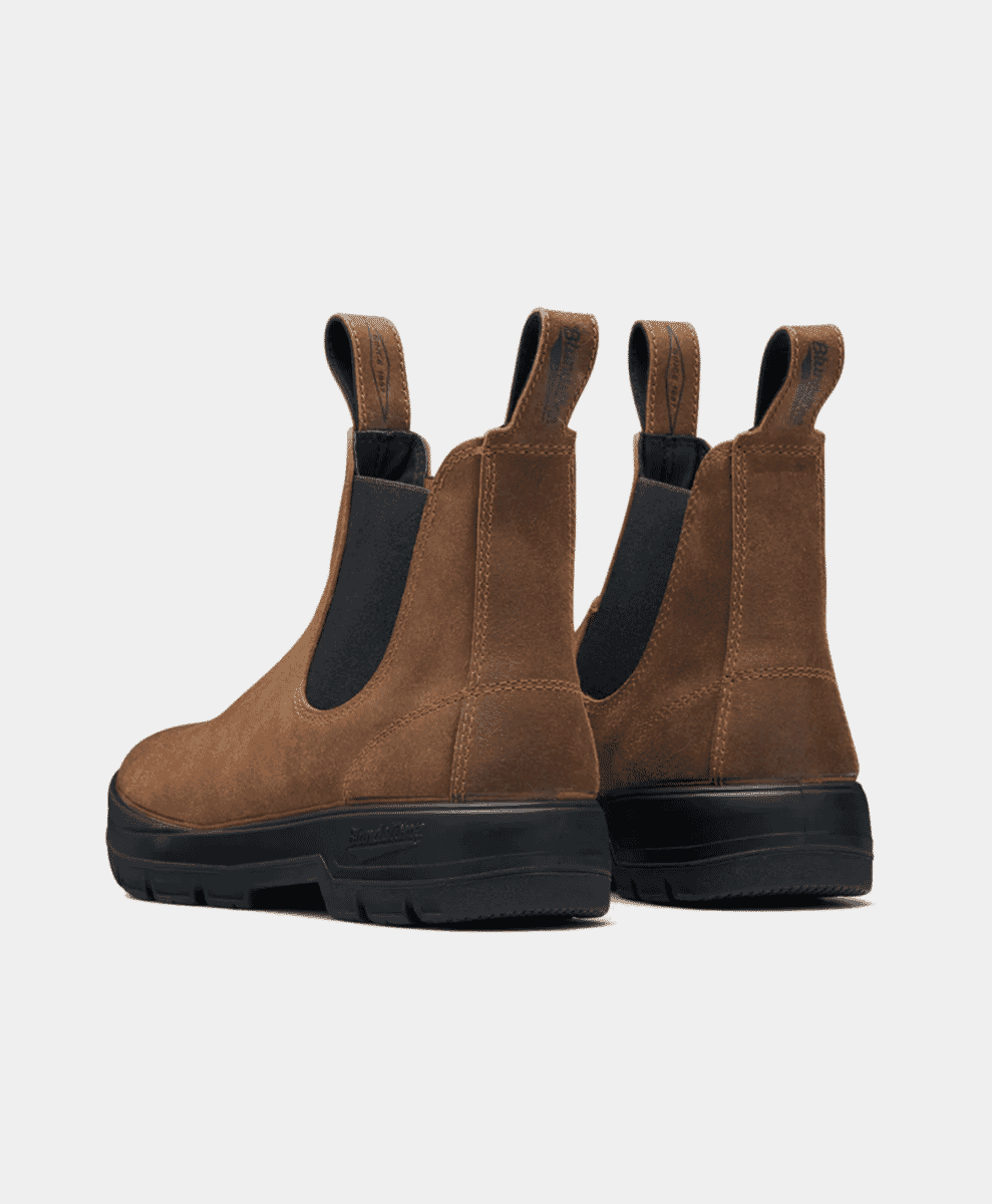 Rear view of a pair of brown suede Chelsea boots showing the pull tabs and rugged black soles.
