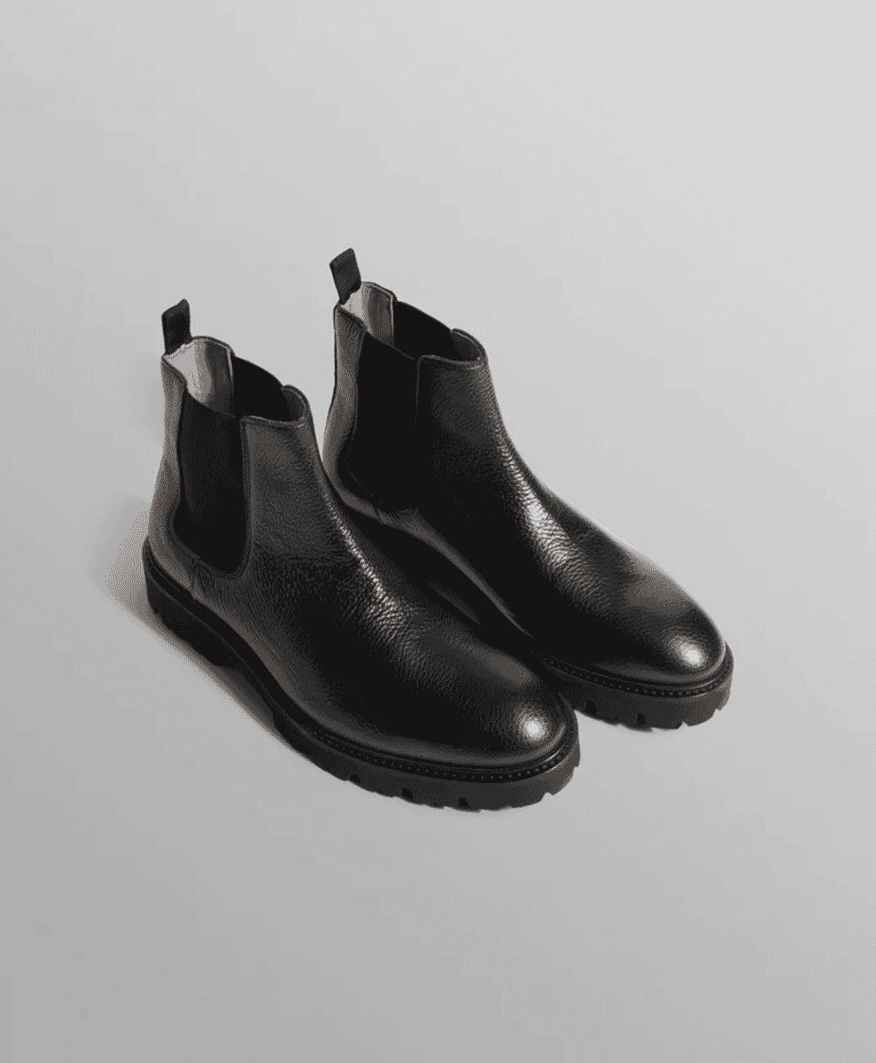 Close-up of black textured leather Chelsea boots with chunky soles.