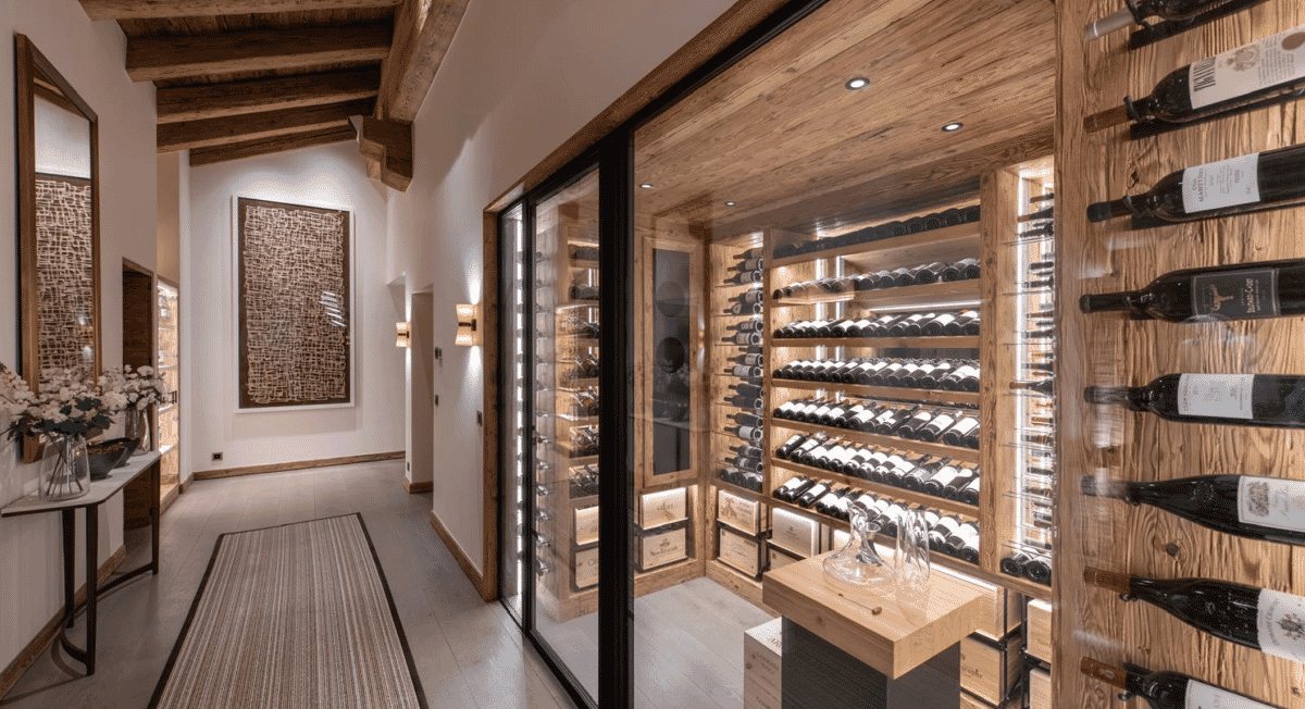 Luxurious wine cellar with wooden shelves and a central tasting table under ambient lighting.