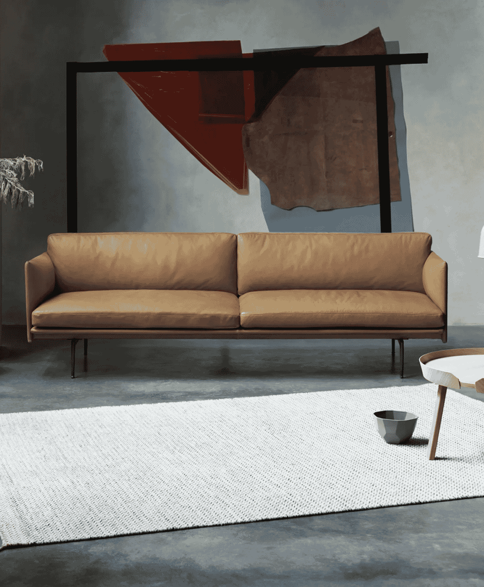 Cognac leather Muuto sofa by Anderssen & Voll in a minimalist interior with abstract art.