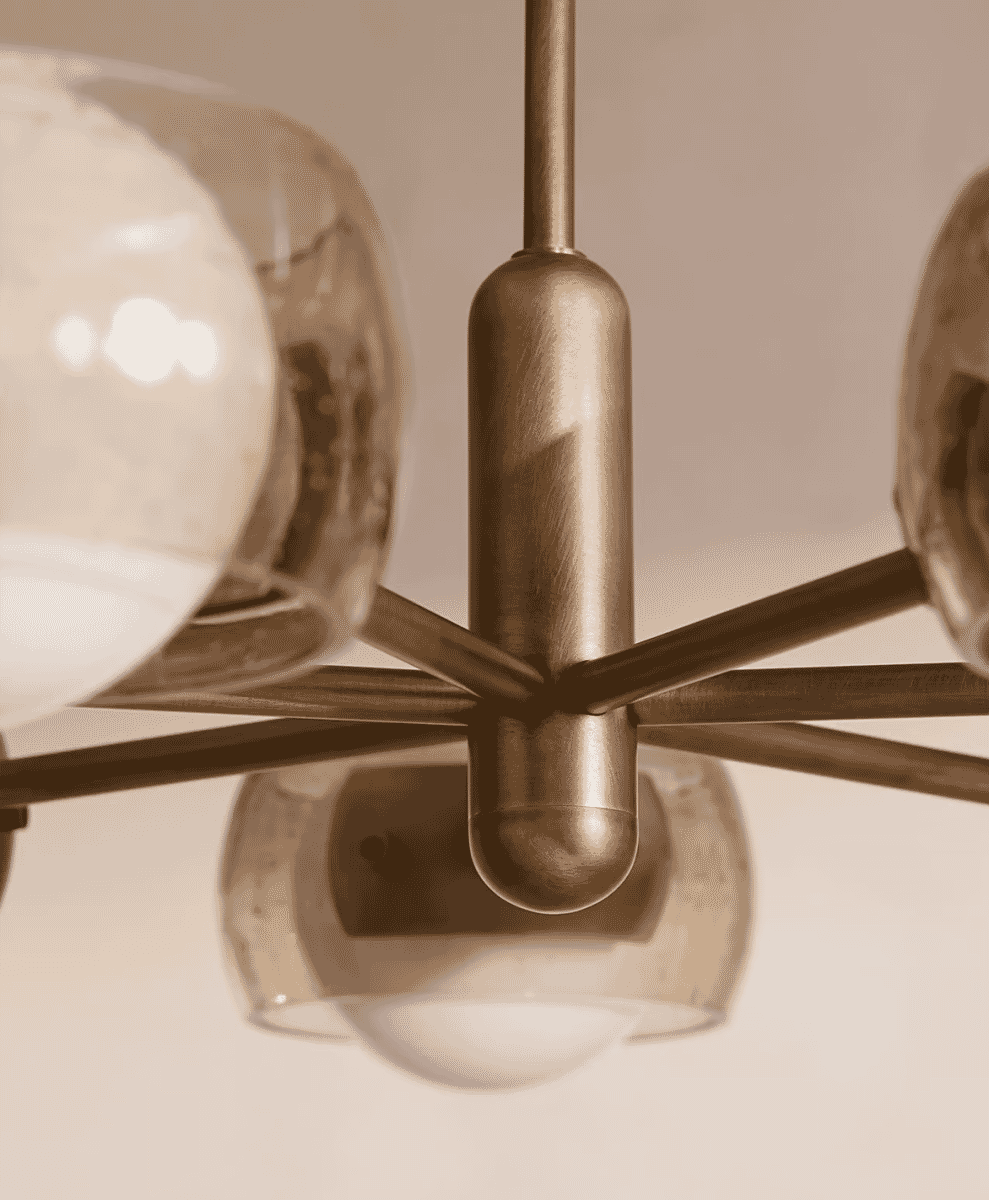 Mid-century modern brass chandelier with frosted glass globes.