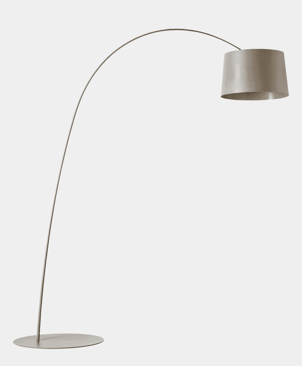 A minimalist silver arc lamp with a cylindrical neutral fabric shade against a clean background.