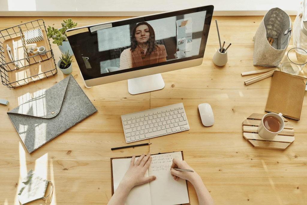 A person in a brown blazer over a white top seen on a laptop screen during a video call.