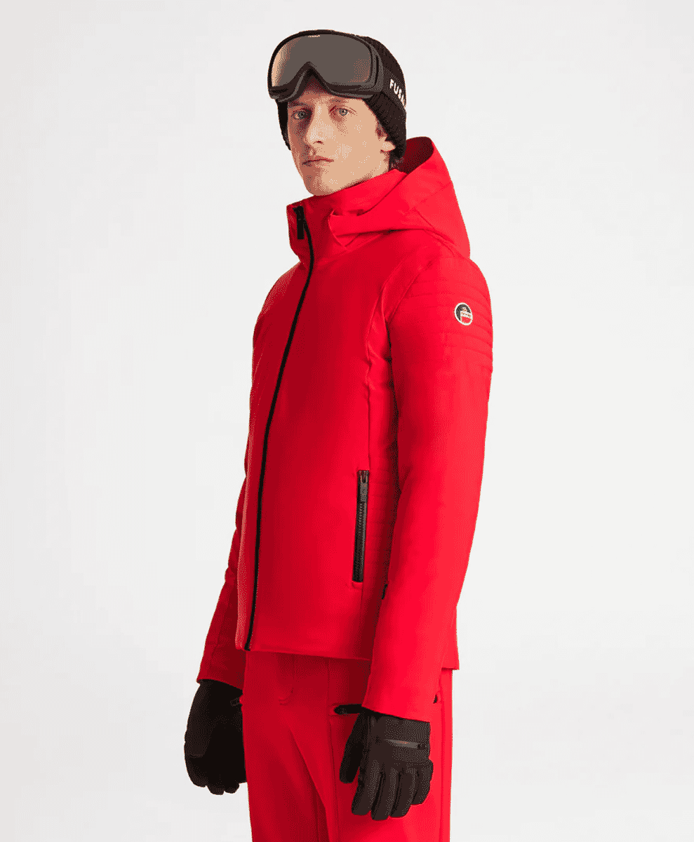 A male model in a vibrant red ski jacket with matching pants and goggles.