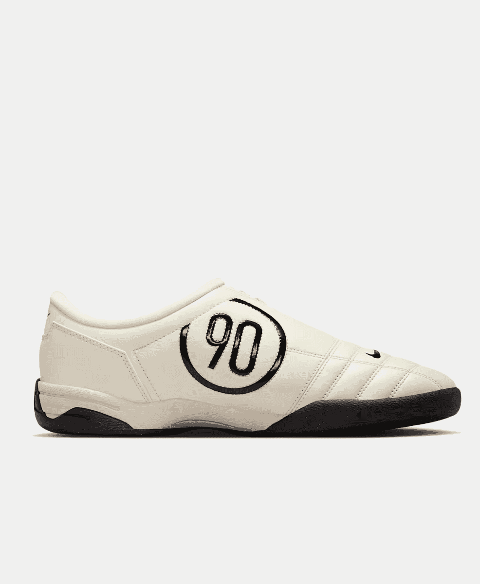 White Nike Total 90 shoe featuring a bold black logo and offset laces.