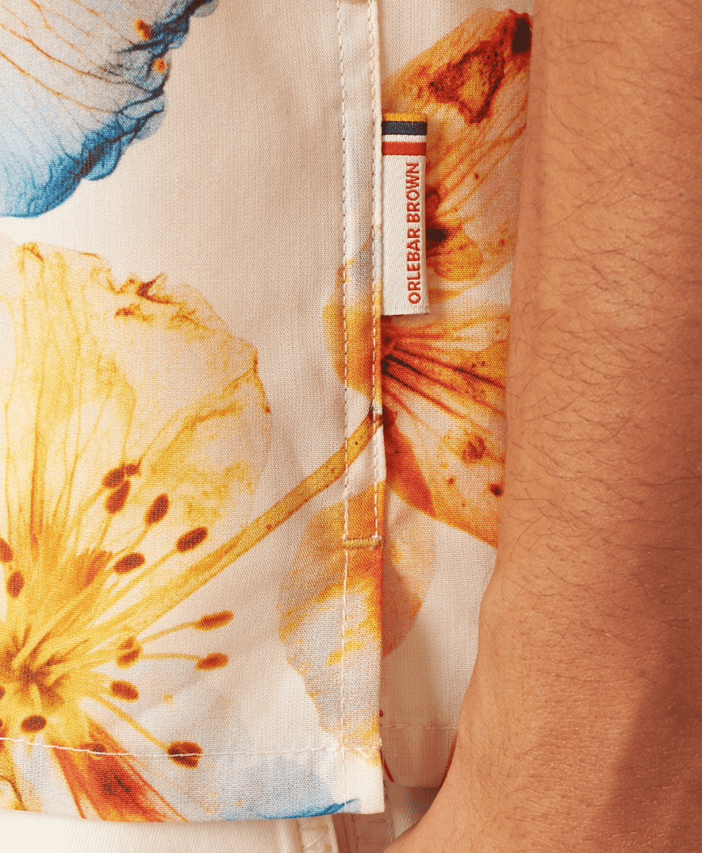 Close-up of Orlebar Brown shirt with yellow and blue botanical designs.