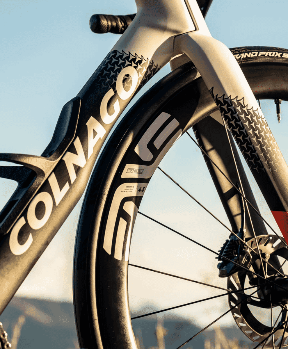 Macro shot of a Colnago road bike frame featuring white paint and star-patterned decals.
